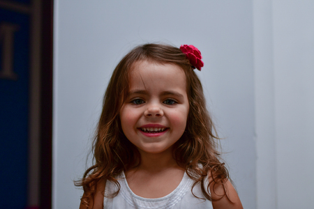 the little smiles girl with a flower in her hairの写真素材