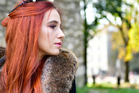 sexy, long-haired, young girl on the cobblestones in front of a stone fortress and metal iron door...