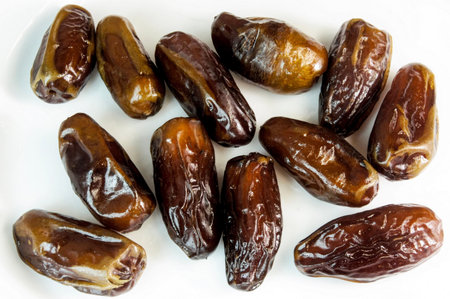 dates. dried dates on a white background. sweet fragrant delicious brown shiny dates. dried fruitsの写真素材