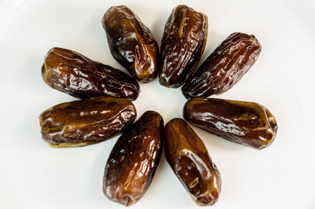 dates. dried dates on a white background. sweet fragrant delicious brown shiny dates. dried fruitsの写真素材