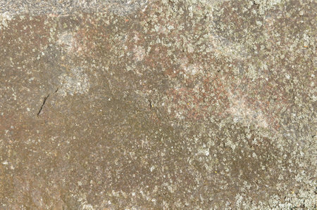 old stone with little green lichen close up. stone textures and pattern. stone backgroundの写真素材