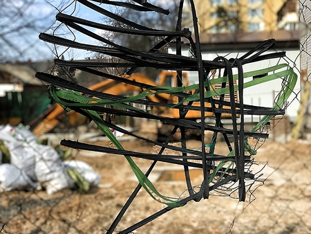 Closeup on barbed wire against the blurred background of a yellow excavator on a construction site