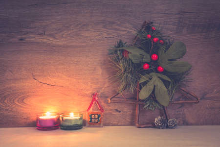 Merry Christmas concept, burning candles, Christmas tree, berries, little house from glass