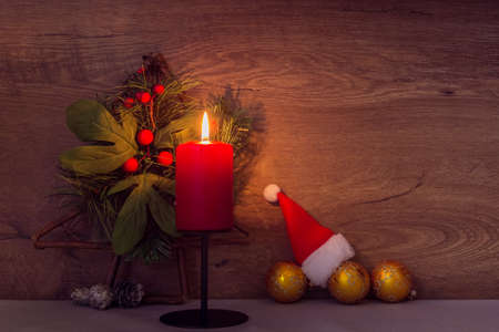 Christmas decoration with burning red candle on table