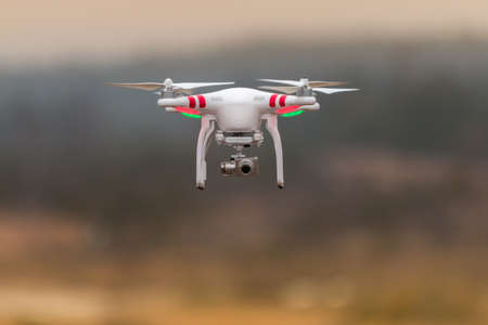 Drone quadcopter with digital camera flying at sunsetの写真素材