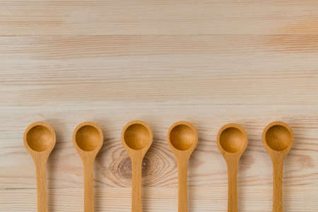 Wooden spoons on wooden background. Set of utensils in vintage style. Background for copy space.の写真素材