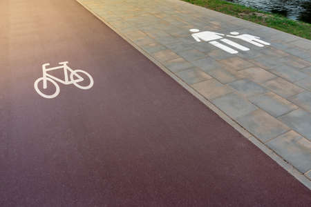 Traffic signs on bicycle path and sidewalk for pedestrians near river in sunny afternoon. Road safety concept.の写真素材