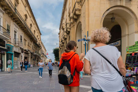 People in street with traditional houses in Valletta old town, the capital of Maltaのeditorial素材