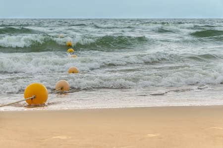Swimming place on beach and in sea area fenced with rope with floats. Seaview with swimming area fenced with buoysの写真素材