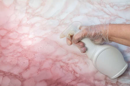 Surface sprayed with disinfectant fluid to kill coronavirus on touching surfaces. Hand with disinfecting fluid in bottle for killing coronavirus. Prevention of covid-19 coronavirus conceptの写真素材