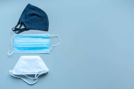 Different face masks and respirator on blue background. Protection against virus