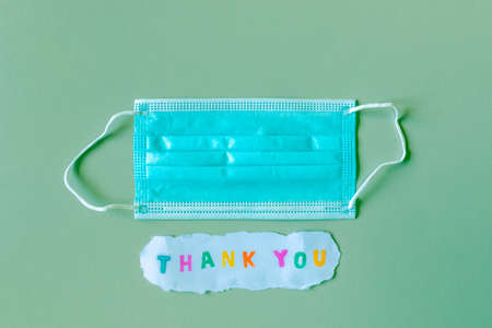 Words THANK YOU on paper below medical face protection maskの写真素材