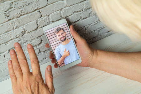 Guy making video call to mom during quarantineの写真素材