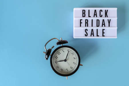 Black Friday sale text on white lightbox and alarm clock on blue background. Thanksgiving promotion advertising. Black Friday sign with copy space.の写真素材