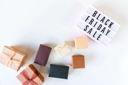 Inscription Black Friday sale on white lightbox and gift boxes on white background. Black Friday...