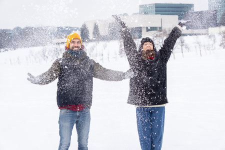 Couple throwing snow and enjoying winter. Couple throwing snow and enjoying winter time in field, full of snowの写真素材