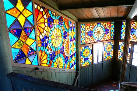 Tbilisi, Georgia - September 2019: Colorful stained glass window. Old house with wood balcony in the old town of Tbilisi. Interior of famous traditional old wood Georgian house with colorful stained glass windows and wooden staircaseの写真素材
