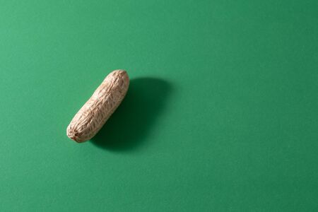 Peanut pattern design concept. Inshell nuts on a green colour background. Top view. Close up. Flat layの写真素材