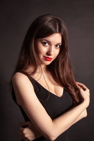 Portrait of beautiful brunette woman in black dress. Fashion photo.の写真素材