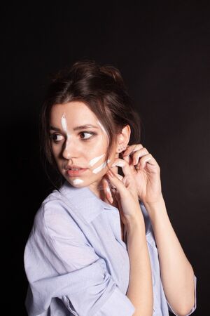 Fashion beauty portrait of beautiful young brunette woman. White paint on the body and face.の写真素材