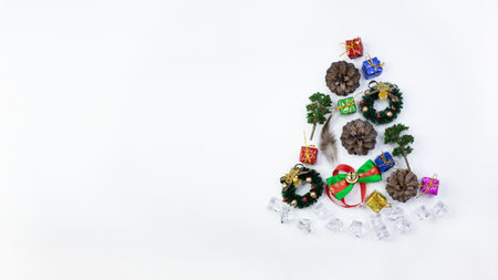 Christmas decoration flat layout composition , copy space, new year concept, decorate with christmas wreath, pine cones, gift boxes, bell, branches, ice rocks in christmas tree shape.の写真素材