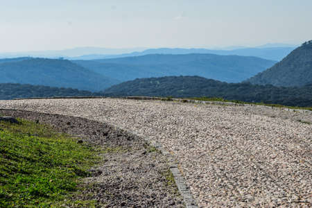 A beautiful road out of stones passing through the green mountains and olive hills in Andalusia, Spain.の写真素材