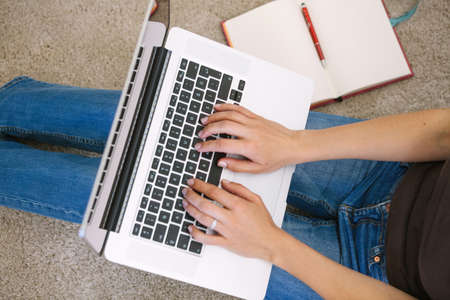 Young woman using laptop in living room at home