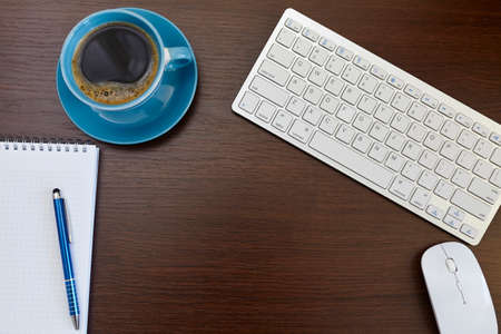 Office leather desk table with computer, supplies and coffee cup.の写真素材