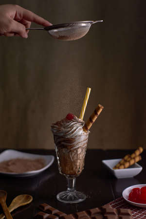 Chocolate milkshake with whipped cream with chocolate wafer and chocolate powder