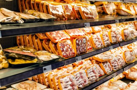meats packed and stacked on the shelves of the supermarket for retail sale of great varietyの写真素材