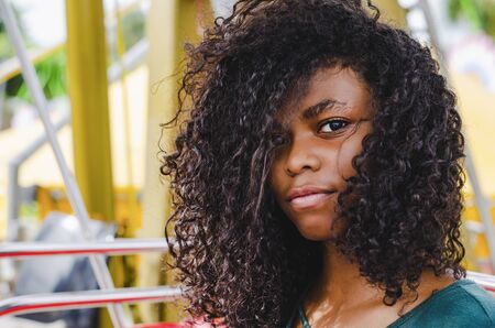 young girl of black color, laughing hair in ferris wheel, sitting enjoying a summer day, lifestyle portraitの写真素材