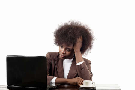 Young black Hispanic business woman, with afro hair, with worried gesture looking at her laptop, in white backgroundの写真素材