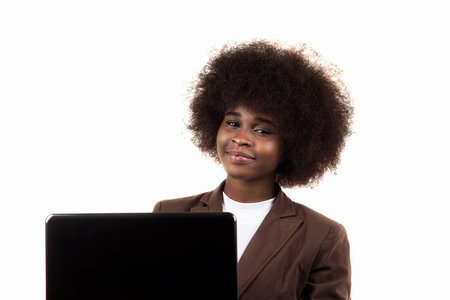 Young black Hispanic Latina business woman, with afro hair, smiles drinking coffee in her office on white backgroundの写真素材