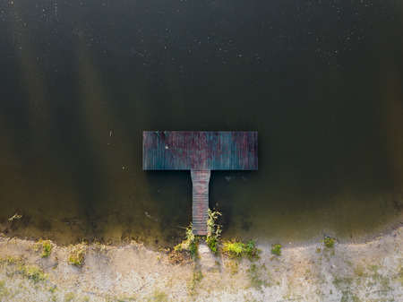 Old wooden pier in calm river from above in the morning. Susrise in nature.の写真素材