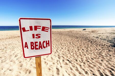 Life is a Beach Sign on Sunny day in Summertime at Sandy Beachの写真素材