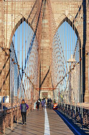 NEW YORK CITY - OCTOBER 26: The pedestrian walkway along The Brooklyn Bridge in New York City on October 26, 2013. Approximately 4,000 pedestrians and 3,100 cyclists cross this historic bridge each day.のeditorial素材