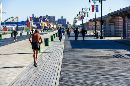 BROOKLYN, NEW YORK, USA - OCTOBER 27: Senior people Walking and Biking on Coney Island Board Walk in the sun and have active and healthy lifestyle at Brighton Beach, Brooklyn NY at October 27, 2013.のeditorial素材