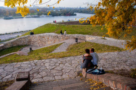BELGRADE, SERBIA - NOVEMBER 8: Young Romantic Couples seating on the fortress wall on beautiful fall afternoon in Belgrade, Serbia on November 8, 2014.のeditorial素材