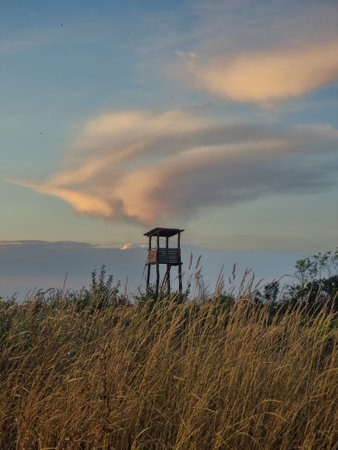 Hunting cabine in orange autumn nature, warm sunset light with cloudsの写真素材
