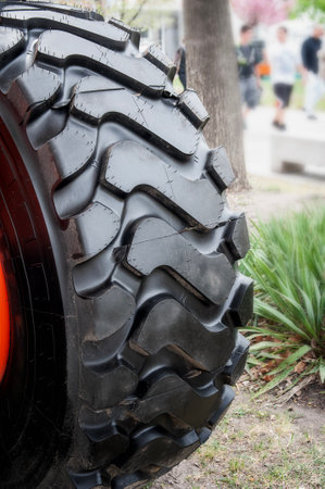 Close up photo of fragment huge tire wheel of construction or agriculture automobile equipment