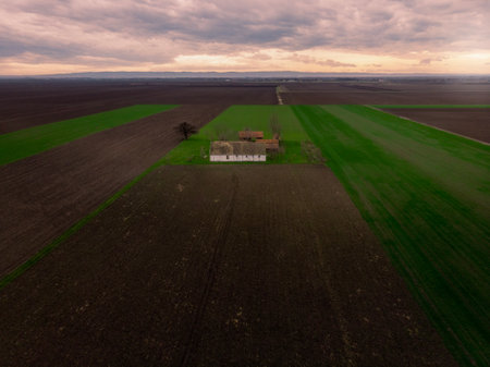 Aerial flight over Winter Agricultural fields with abandoned ranch during Sunset. Vojvodina, Serbia, Europe.の写真素材