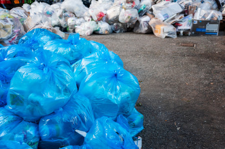 Pile of Garbage plastic blue and trash bag waste many on the footpath, pollution trash, Plastic Waste and Bag Foam tray Garbage many on floor, Waste plastic.の写真素材