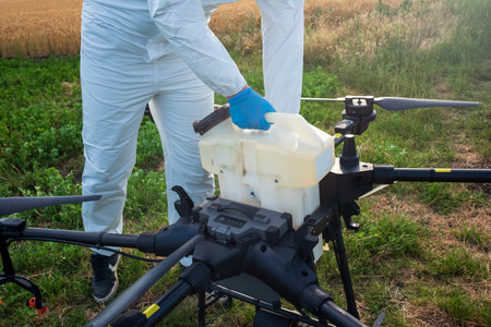 Modern technologies in agriculture. Industrial drone at green field for spraying pesticides to increase productivity and destroys harmful insects. Technologies in farmingの写真素材