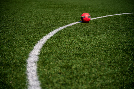 A soccer ball lies on the ground in a green field in natural light. Football Theme Background.の写真素材