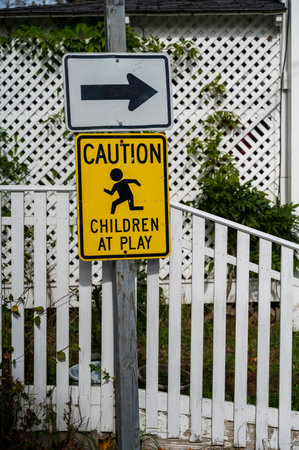 Caution Children at Play Road Sign in City near Family Housesの写真素材