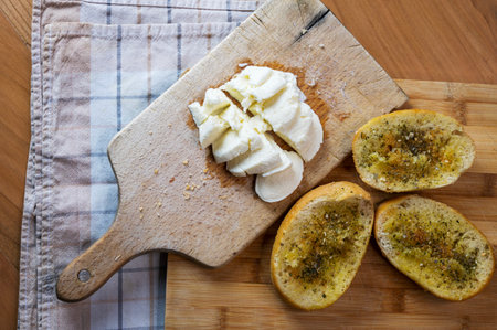 Mozzarella and garlic Bread on wooden plate for traditional mediterranean breakfast, healthy vegetarian morning routineの写真素材