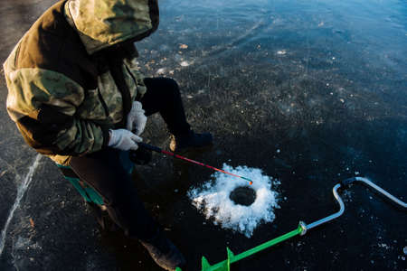 A man is fishing on the ice in the winter. Winter fishingの写真素材