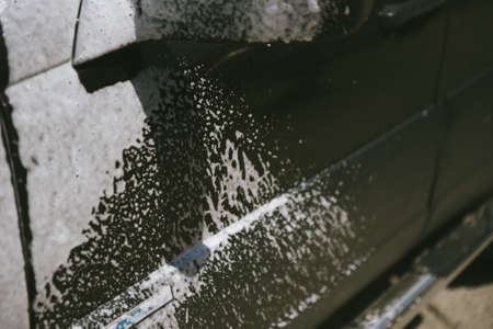 Machine in the foam. Car wash. Car in the foam from the cleaning agent. Parts of the machine in the relicsの写真素材
