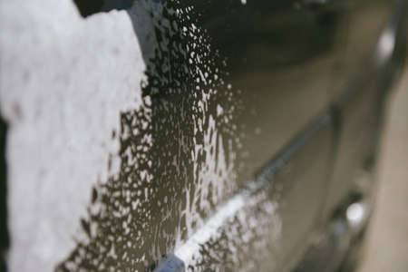 Machine in the foam. Car wash. Car in the foam from the cleaning agent. Parts of the machine in the relicsの写真素材
