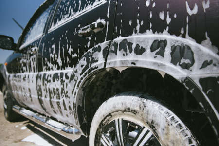 Machine in the foam. Car wash. Car in the foam from the cleaning agent. Parts of the machine in the...